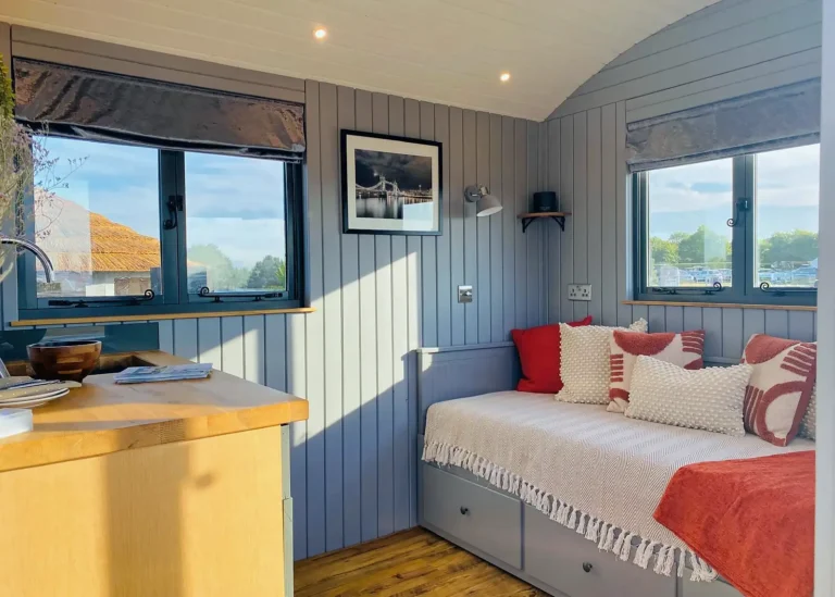 The Lodge shepherd hut interior with day bed and kitchenette area
