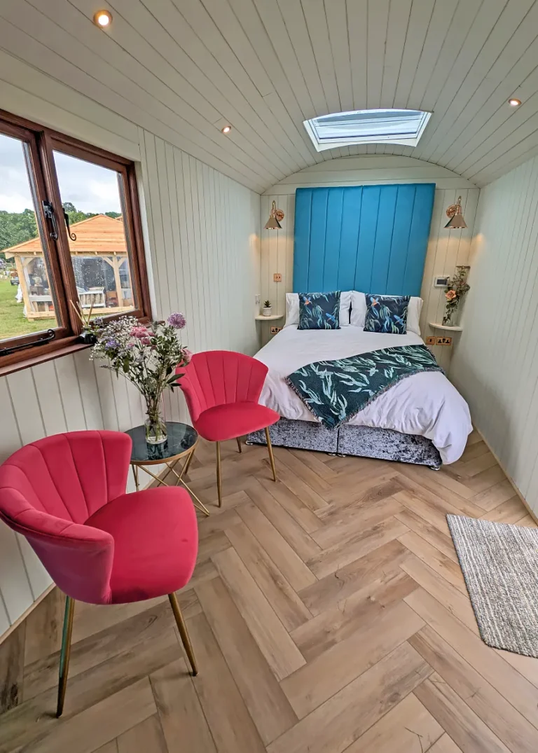 The Grand hut with a double bed and seating area from Belringham Shepherd Huts