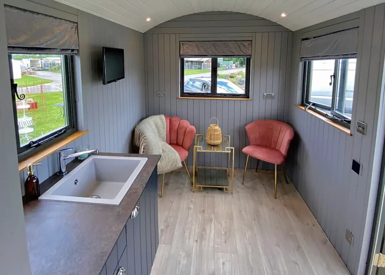 The Haven 2 Seating Area with two chairs and wood laminate floor by Belringham Shepherd Huts