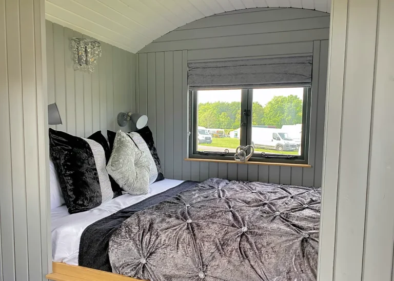 The Lookout cozy bed area with side window by Belringham Shepherd Huts
